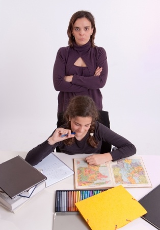 Teenager studying with parent watching